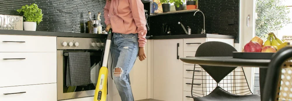 Person reinigt Boden mit Dampfreiniger